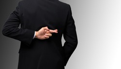 Dishonest businessman telling lies, lying male entrepreneur holding fingers crossed behind his back