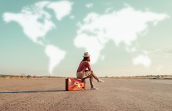 Traveler woman sitting on a suitcase and dreaming about adventures. Map of the world is painted in sky. Concept of travel