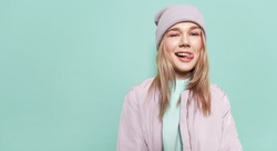 Laughing girl in a  in stylish casual clothes and shows tongue