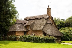 An old thatched cottage nestling in trees