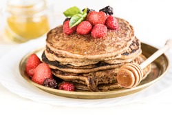 Buckwheat pancakes with berry fruit,honey and sugar powder,selective focus 
