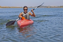 Bronzed man riding by kayak