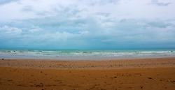 Overcast Cable Beach, Broome, North Western Australia on a late cloudy humid dull afternoon in the summer Wet Season is reflected in the stormy waves and brooding skyscape.