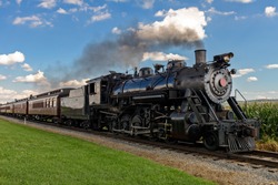 historic steam train passes through the fields