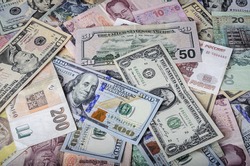 A collection of various foreign currencies from countries spanning the globe. Many different currencies as colorful background concept global money. Soft selective focus and shallow depth of field