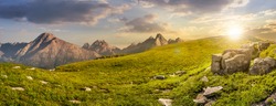 High Tatra mountain summer landscape. meadow with huge stones among the grass on top of the hillside near the peak of mountain range at sunset