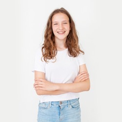 happy laughing teenage girl isolated on a white background. Emotional teenager in a white T-shirt