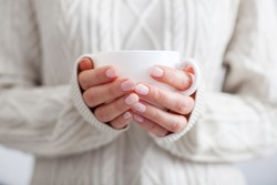 Coffee mug in female hands. Woman drinking hot coffee