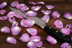 closeup butcher knife with pink rose petals