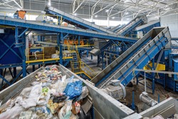 Waste sorting plant. Many different conveyors and bins. conveyors filled with various household waste.