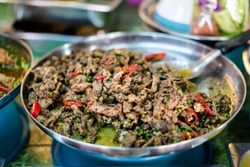 Fresh asian spicy green pepper corns and chilli pork slices on local market in Krabi town. Traditional thai cuisine made of fresh ingredients.