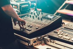 professional stage sound mixer closeup at sound engineer hand using audio mix slider working during concert performance