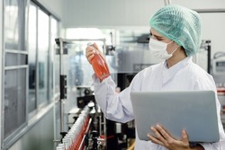 Quality control and food safety inspector test and check product contaminate standard in the food and drink factory production line with hygiene care.