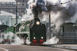 Retro train departs from railway station building. Moscow. Russia.