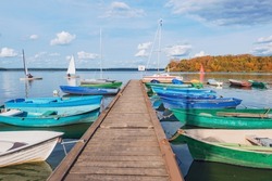 Boats by the pier. Lake view at autumn day time.