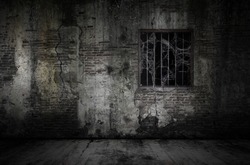 Window and rusty bars covered with cob web or spider web on prison old bricks wall and dusty floor, concept of horror and Halloween