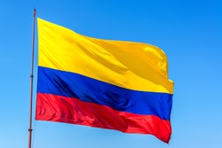Resplendent Colombian flag waving in the wind set against a beautiful blue sky