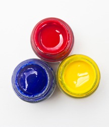 Top view of opened bottles of primary color on white background.