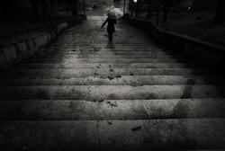 The descent/A person going down the stairs with an umbrella during a heavy rain. Orsova, Romania, May 15, 2010