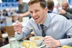 Young handsome businessman eating lunch in a cafe