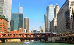 Buildings and bridges, with an elevated train, looming above the Chicago River