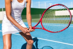 Tennis woman in sport club playing game on outdoor blue hard court in white skirt sportswear outfit.