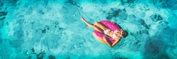 Beach vacation woman relaxing in pool float donut inflatable ring floating on turquoise ocean water background in Caribbean travel summer banner panorama. Girl in white bikini top drone view.
