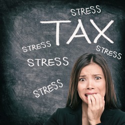Tax season stress stressed Asian woman biting nails anxious late to file tax paperwork for IRS. Black chalkboard background with text written for income tax returns.