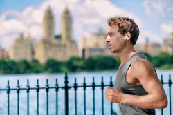 Wireless earbuds man running in Central Park New York city listening to music with wearable technology bluetooth earphone device.