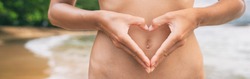 Heart shape hands on healthy stomach woman banner panoramic. Early pregnancy, probiotic digestion, healthy gut health.
