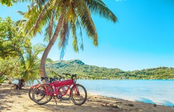 Cycling tourism e-bike bikes biking tour excursion tourists summer vacation travel landscape. Tahiti island bicycles on beach.