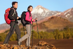 Hikers people hiking - healthy active lifestyle. Hiker people hiking in beautiful mountain nature landscape. Woman and man hikers walking during hike on volcano Teide, Tenerife, Canary Islands, Spain.
