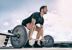 Gym fitness weightlifting deadlift man bodybuilding powerlifting at outdoor summer health club. Bodybuilder doing barbell weight lifting training workout with heavy bar.