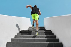 Stairs exercise fitess man running fast up the staircase for hiit cardio workout run at outdoor gym. Sport active athlete lifestyle training legs muscles.