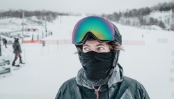 Ski portrait. Iced up frozen ski goggles and ski helmet on man looking at camera with ski goggles icing up in freeze. Concept of Glaze ice, also called glazed frost snow when snowboarding or skiing