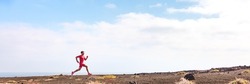 Athlete running man athlete on triathlon run. Hero profile view of runner on hill training hiit workout going uphill. Panoramic landscape crop background