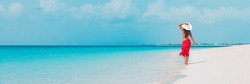 Beach vacation woman walking on summer travel Caribbean holiday wearing white sun hat and sarong skirt. Ocean panoramic banner background. Elegant lady tourist
