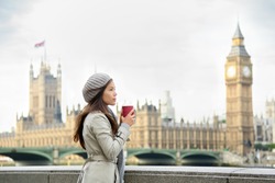 London woman drinking coffee by Westminster Bridge. Serious pensive thoughtful young female professional business woman in London, England. Beautiful young multiracial Asian Caucasian girl.