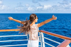 Cruise ship vacation woman enjoying travel vacation at sea. Free carefree happy girl looking at ocean with open arms in freedom pose.