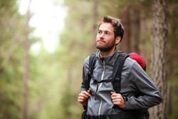 Hiker - man hiking in forest. Male hiker looking to the side walking in forest. Caucasian male model outdoors in nature.