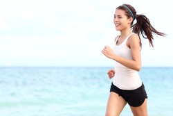 Running woman. Female runner jogging during outdoor workout on beach. Beautiful fit mixed race Fitness model outdoors.
