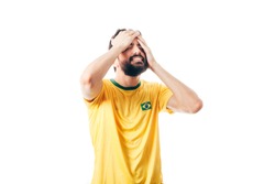 Unhappy Brazilian soccer or football player with palm on his face on white background