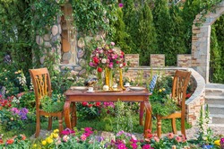 Dining table in landscaped backyard flower garden
