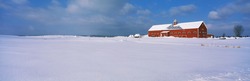 This is a red barn in the snow. It is representative of winter in New England.