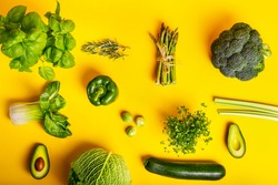 Top view healthy raw green vegetables and greenery on the yellow background Vegetarian and vegan diet. Veganism concept. Sustainable lifestyle, good eats, real plantbased foods. Flatlay