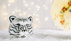 Tiger symbol and chinese bamboo paper fan with traditional chinese ornament. Chinese New Year of the Tiger 2022. Bokeh lights background. Wide banner. Copy space.
