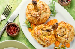 Chicken legs in pastry.Chicken leg in puff pastry on table.Baked chicken