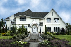 Exterior of white stucco luxury house with landscaped yard