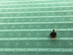Top view of an unidentified Muslim man prays in a mosque