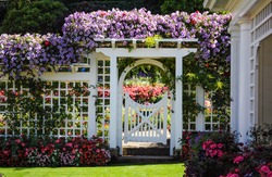 Botanical garden white fence with gate and blooming flowers